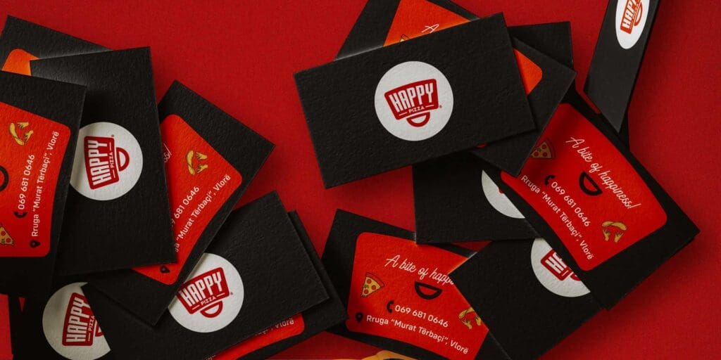 Branding agency designs Happy Pizza’s business cards, offering a taste of the brand's joyous essence at first glance.