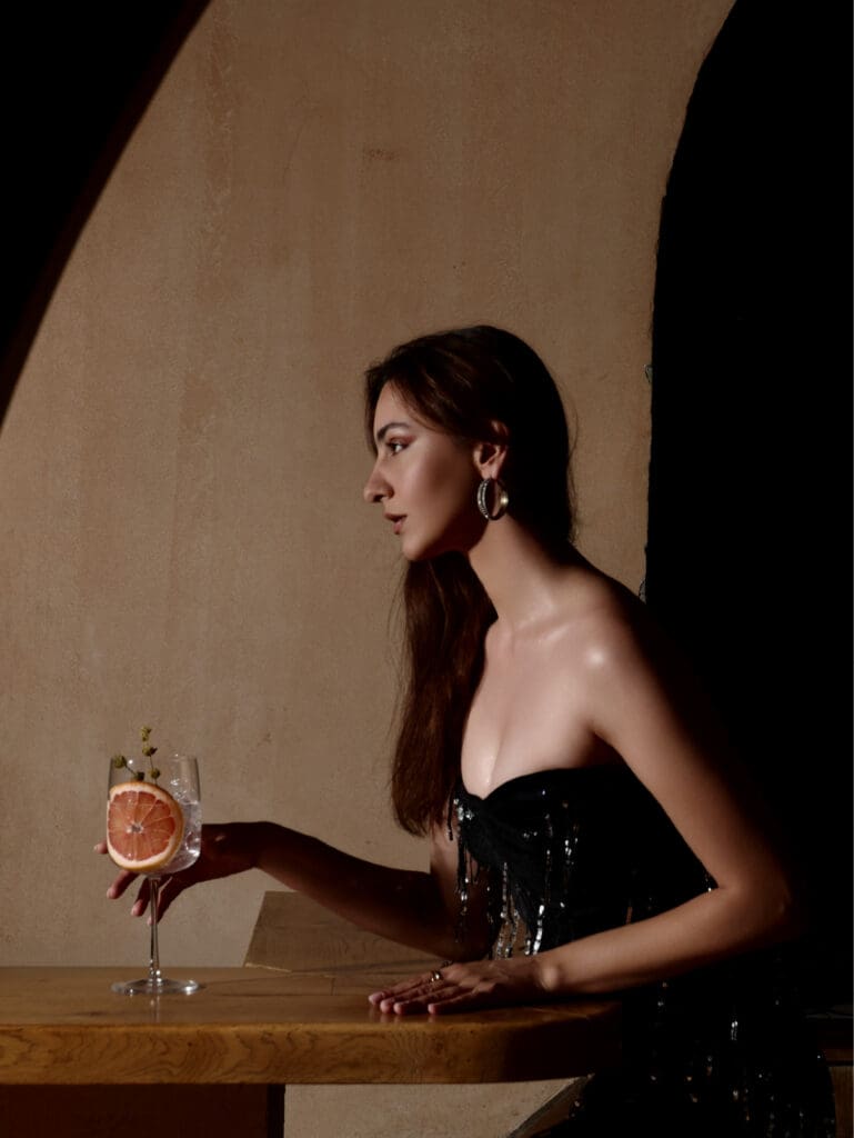 Model posing with cocktail inside EOS Mezze Bar, photographed by an advertising agency in Tirana